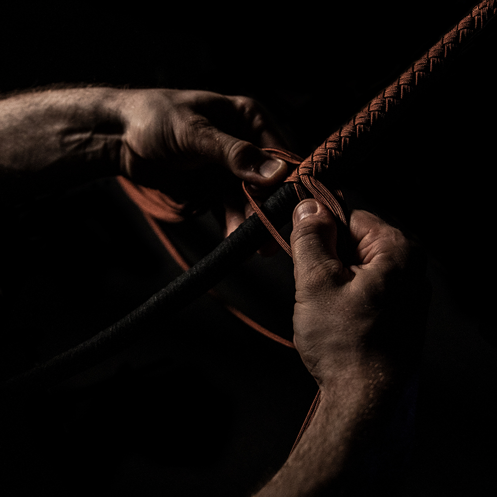 Close-up of hands plaiting paracord