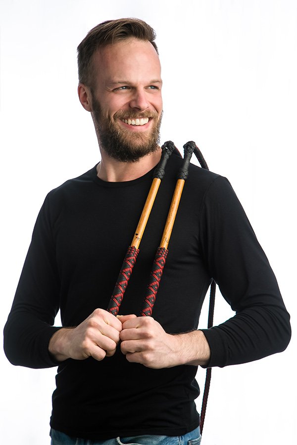 Adam Fieldson, whipmaker, holding two handmade stockwhips